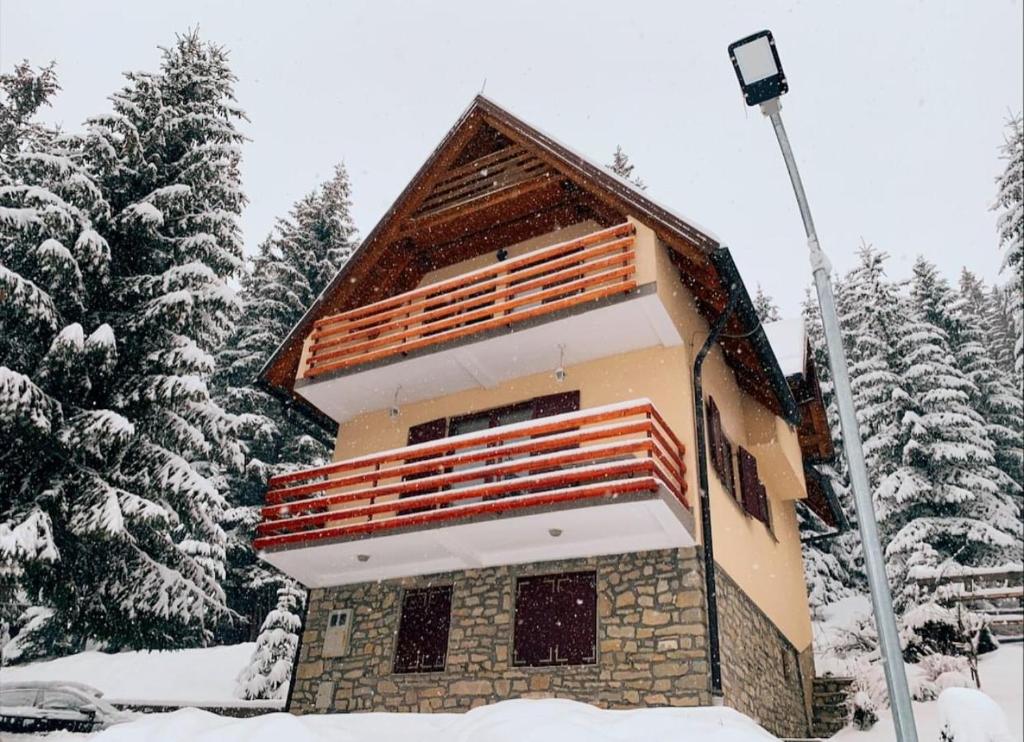 un edificio en la nieve junto a algunos árboles en Villa "Pahulja" - Vlašić, en Vlašić