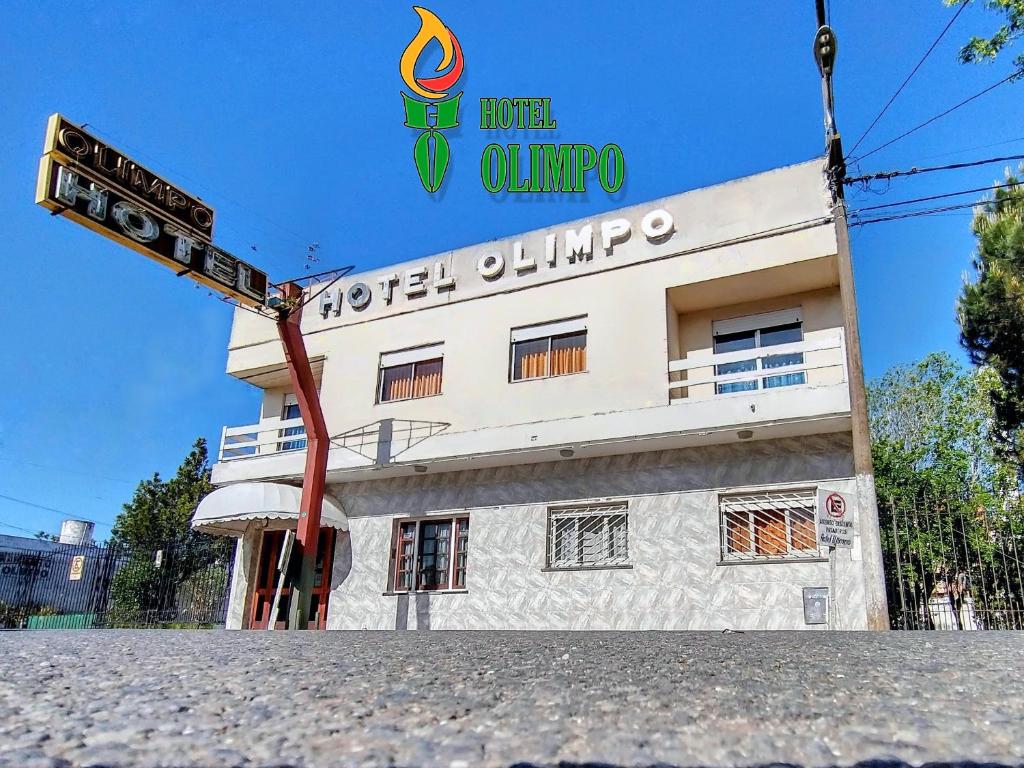 un edificio con una señal delante de él en Hotel Olimpo en Mar de Ajó