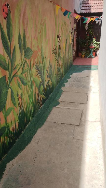 Una pared con un mural de plantas. en Casa al fondo en Mar del Plata