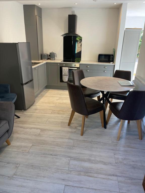 a kitchen with a table and chairs and a refrigerator at Crab Cottage in Wells next the Sea