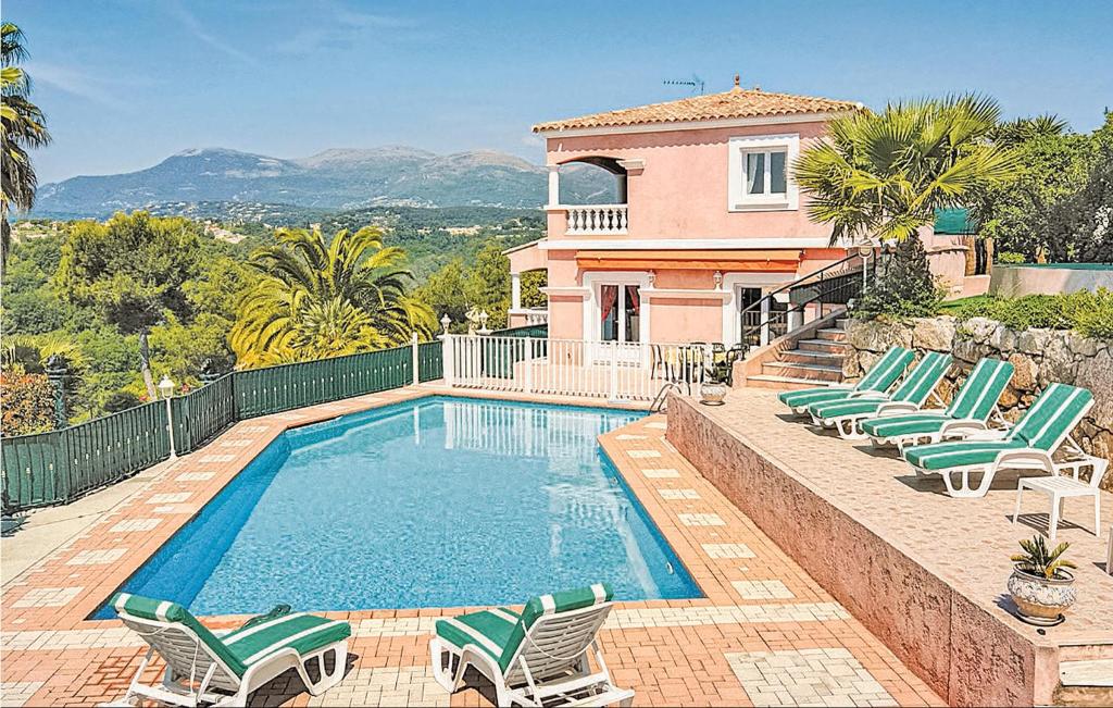 a swimming pool with chairs and a house at Gorgeous Home In Cagnes Sur Mer With Private Swimming Pool, Can Be Inside Or Outside in Cagnes-sur-Mer