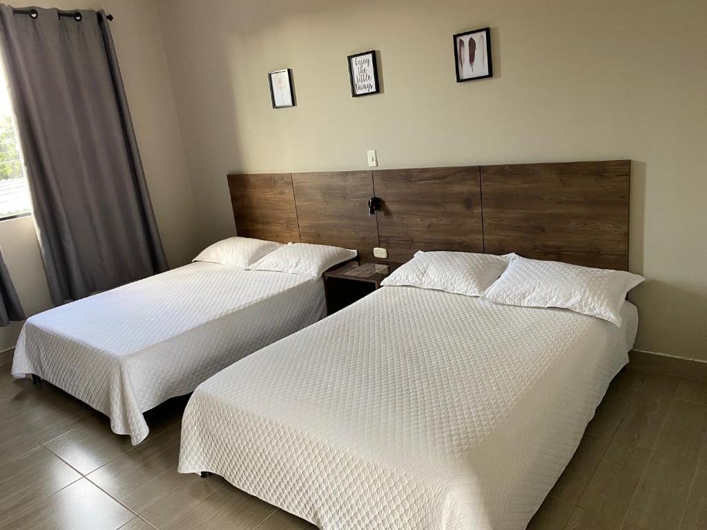 Postel nebo postele na pokoji v ubytování HOTEL MELGAR PLAZA