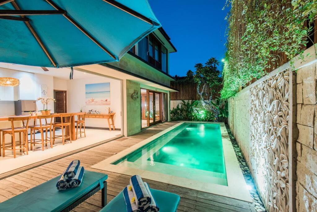 een zwembad in een achtertuin met een tafel en stoelen bij Villa Lacasa3 -Modern tropical 3BR Villa with butler in Legian