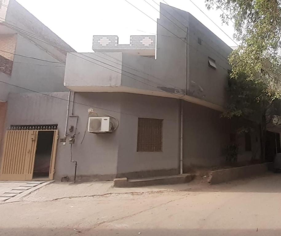 Five Giants Lahore Homestay في لاهور: مبنى عليه شباك وباب