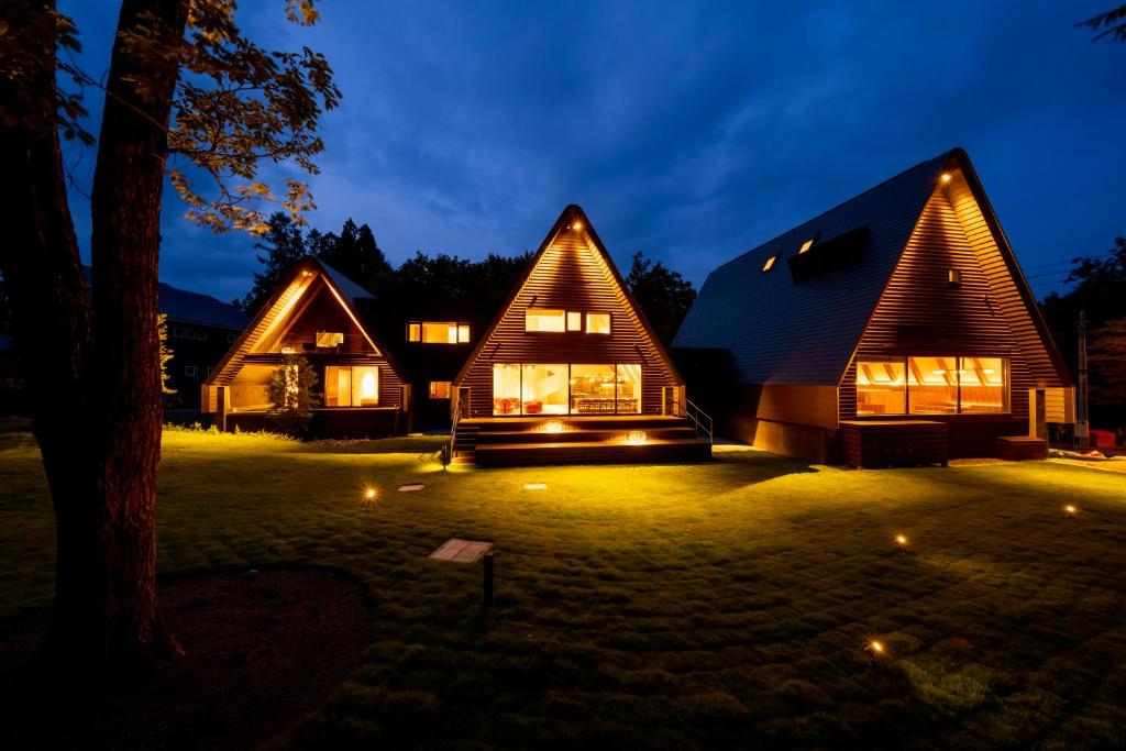a house at night with lights in the yard at KanollyResorts Hakuba in Hakuba