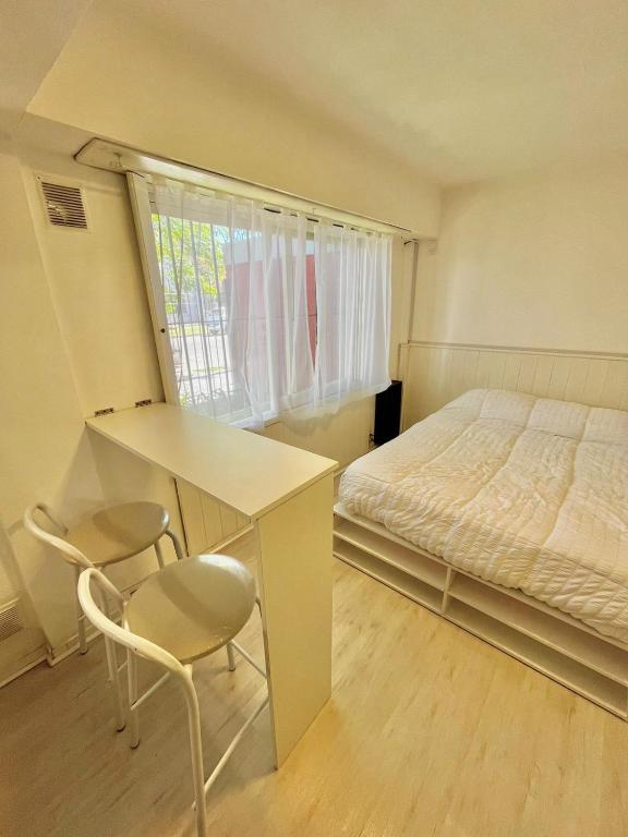 1 dormitorio con 1 cama, escritorio y sillas en Studio en Mar del Plata