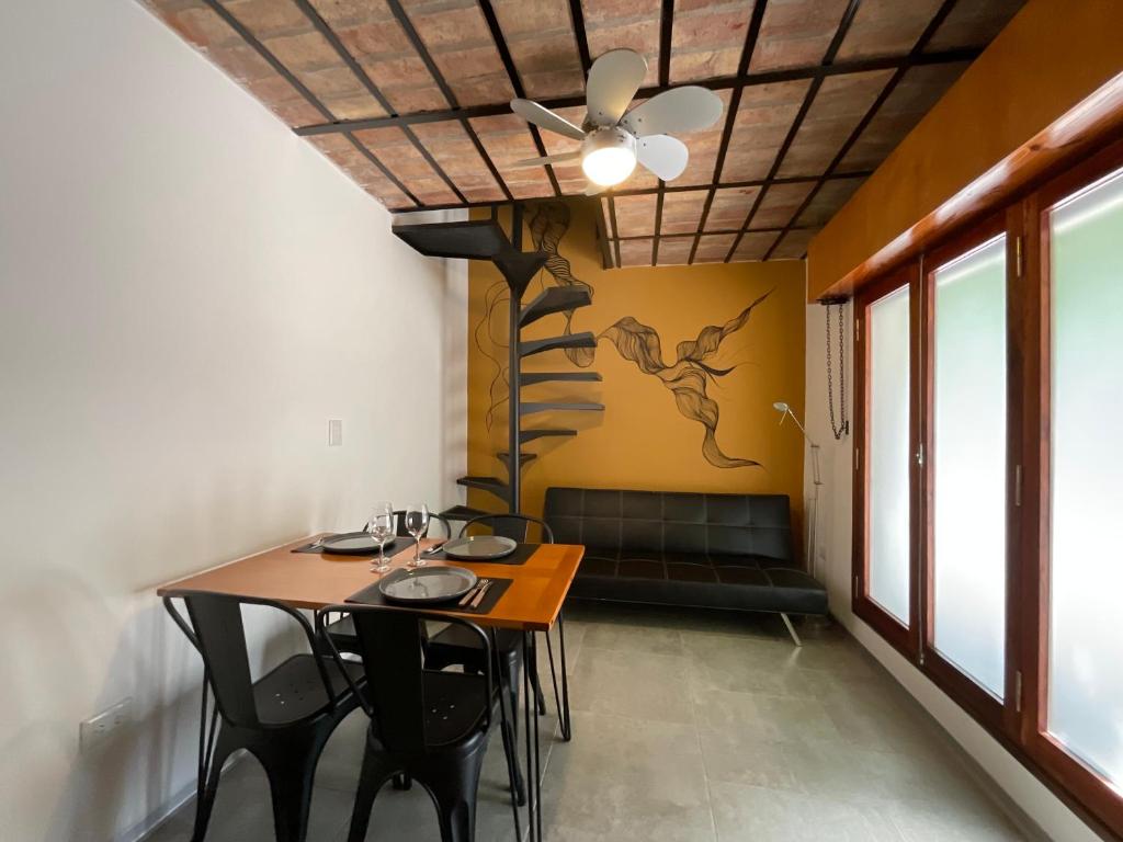 comedor con mesa y sillas y ventilador de techo en Encantador Duplex cerca de todo en Córdoba