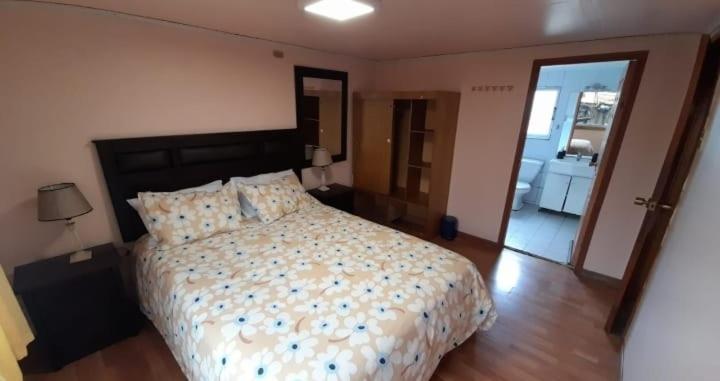 1 dormitorio con 1 cama y puerta a un balcón en Refugio Martin Pescador, en Coyhaique