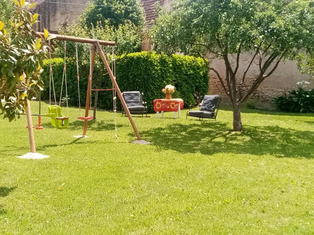 - une aire de jeux avec 2 chaises et une balançoire dans l'établissement Maison en pierre rénovée avec jardin, proche Sarlat, idéale pour familles, avec équipements bébé inclus - FR-1-616-200, à Aillac