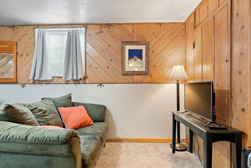 ein Wohnzimmer mit einem grünen Sofa und einem TV in der Unterkunft Exquisite Haven Min To Dt,bsu,& Apt Parking in Boise