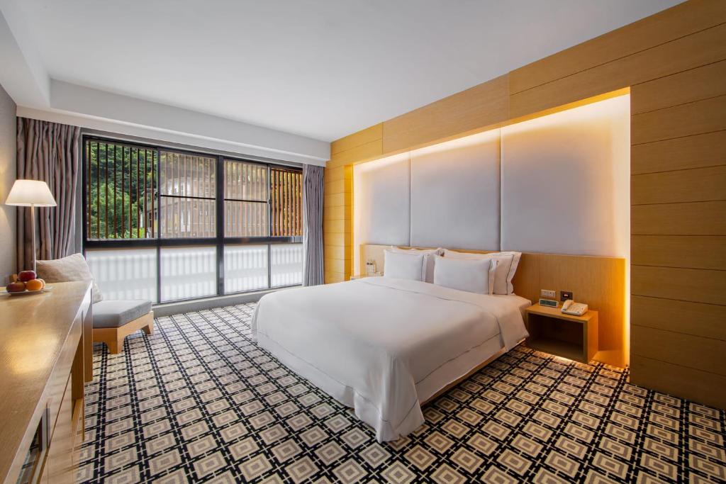 a bedroom with a large bed and a large window at Wulai Pause Landis Resort in Wulai