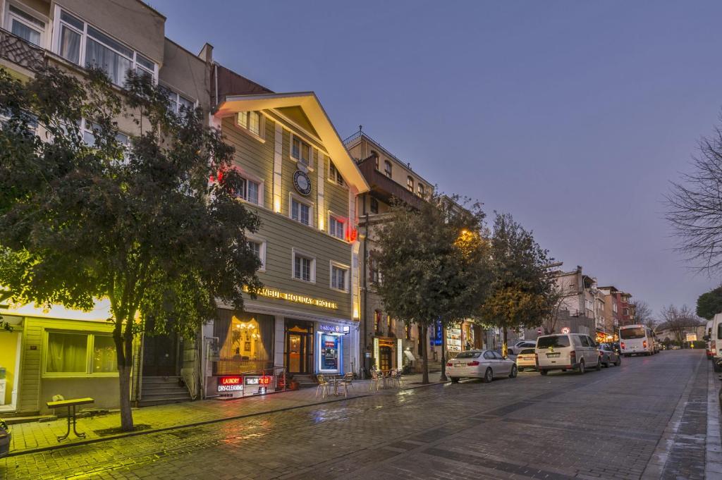 uma rua da cidade à noite com carros estacionados na rua em Istanbul Holiday Hotel em Istambul