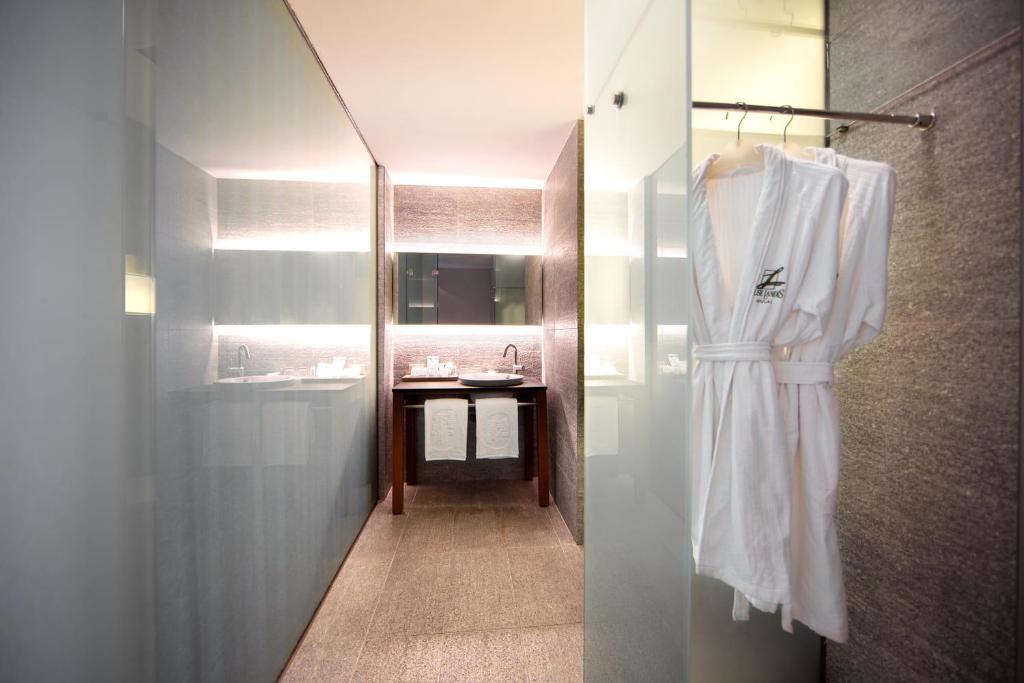 a bathroom with a white robe hanging on a wall at Wulai Pause Landis Resort in Wulai