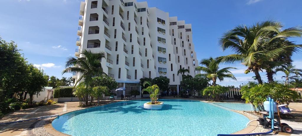 a swimming pool in front of a tall building at Sea sand sun Condominiums in Rayong