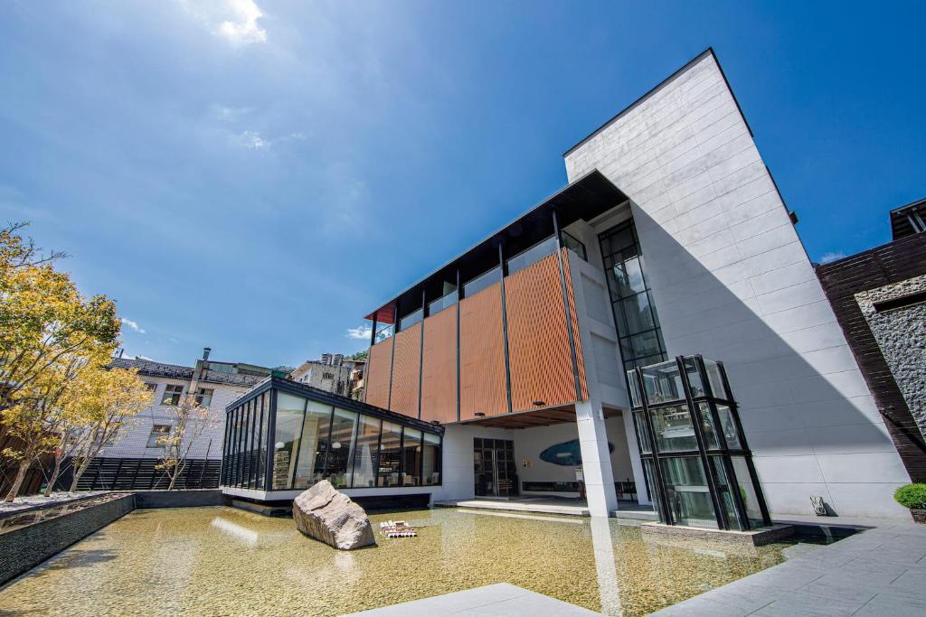 un grand bâtiment blanc avec des portes en verre dans une rue dans l'établissement Wulai Pause Landis Resort, à Wulai