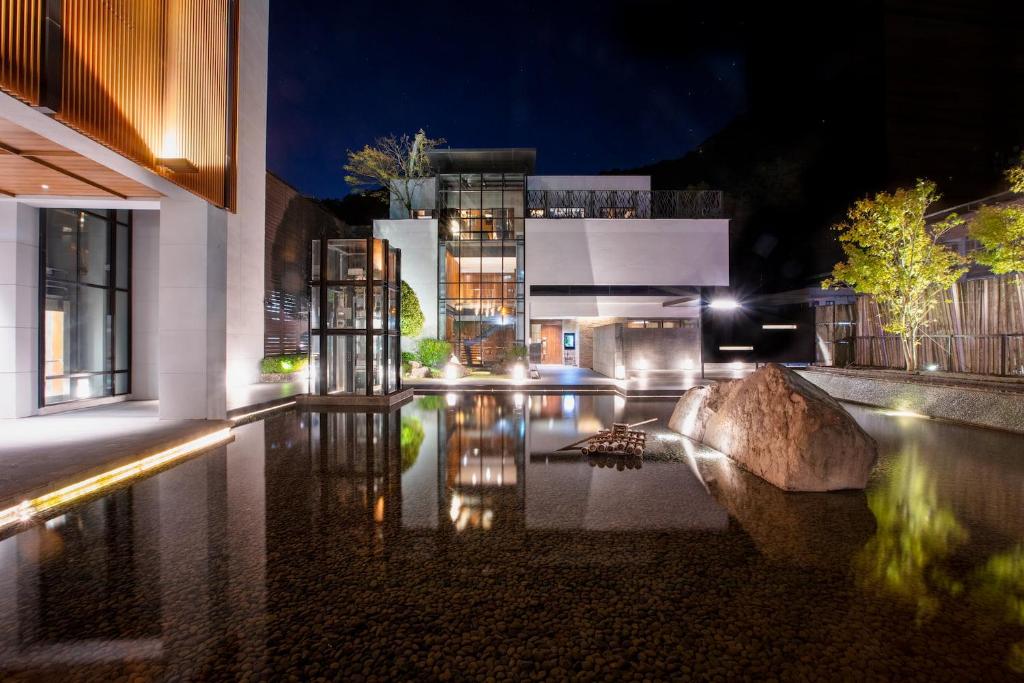 a pool of water in front of a building at night at Wulai Pause Landis Resort in Wulai