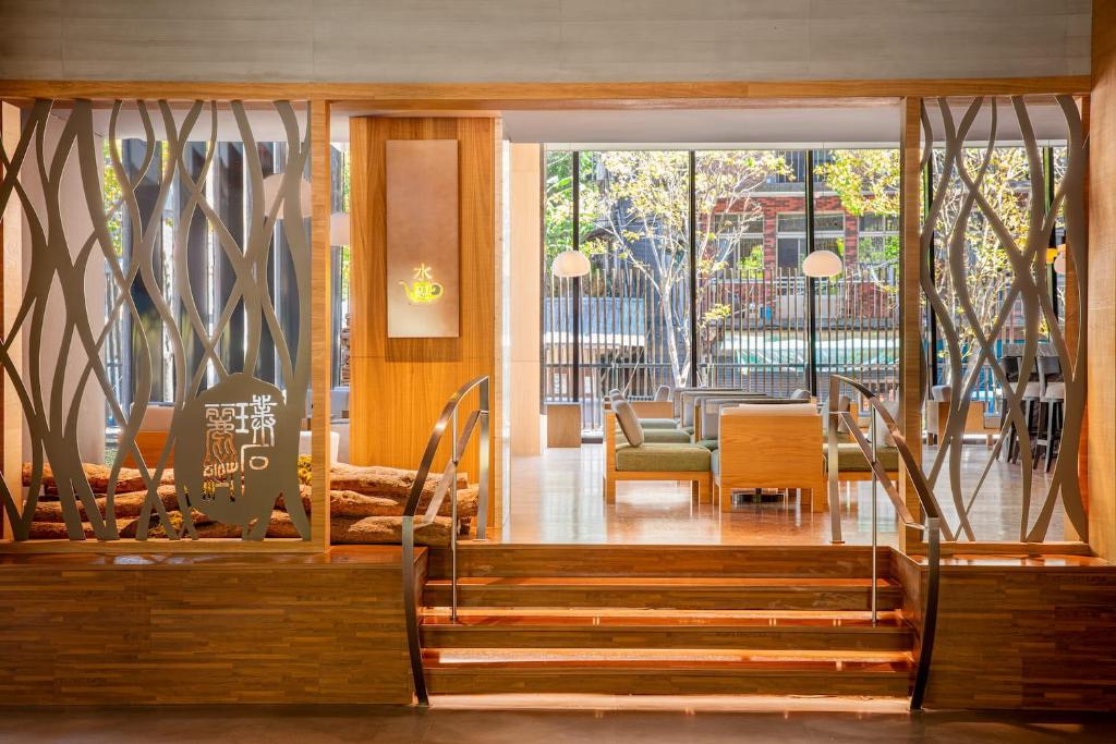 a lobby with stairs and a table and chairs at Wulai Pause Landis Resort in Wulai