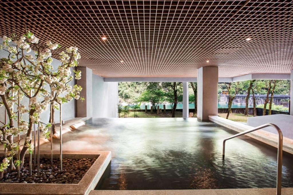 a room with a pool of water in a building at Wulai Pause Landis Resort in Wulai