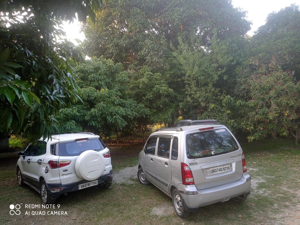 dos coches pequeños estacionados uno al lado del otro en DooN Resort & Farmhouse stay en Dehradun