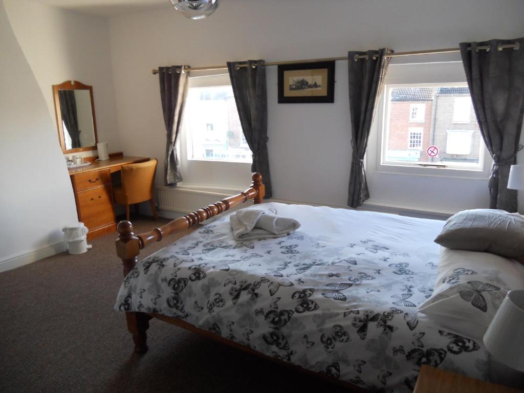 a bedroom with a bed and a window at Yarm View Guest House and Cottages in Yarm