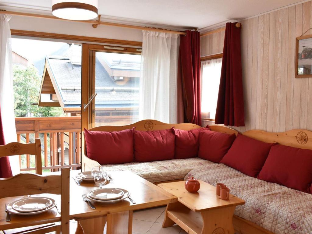 ein Wohnzimmer mit einem roten Sofa und einem Tisch in der Unterkunft Appartement Méribel, 2 pièces, 4 personnes - FR-1-180-378 in Les Allues