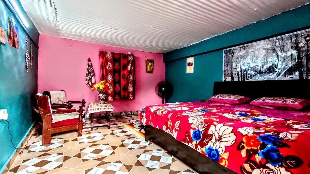 a bedroom with a red bed and a pink wall at The Chakras Valley Homestay in Almora