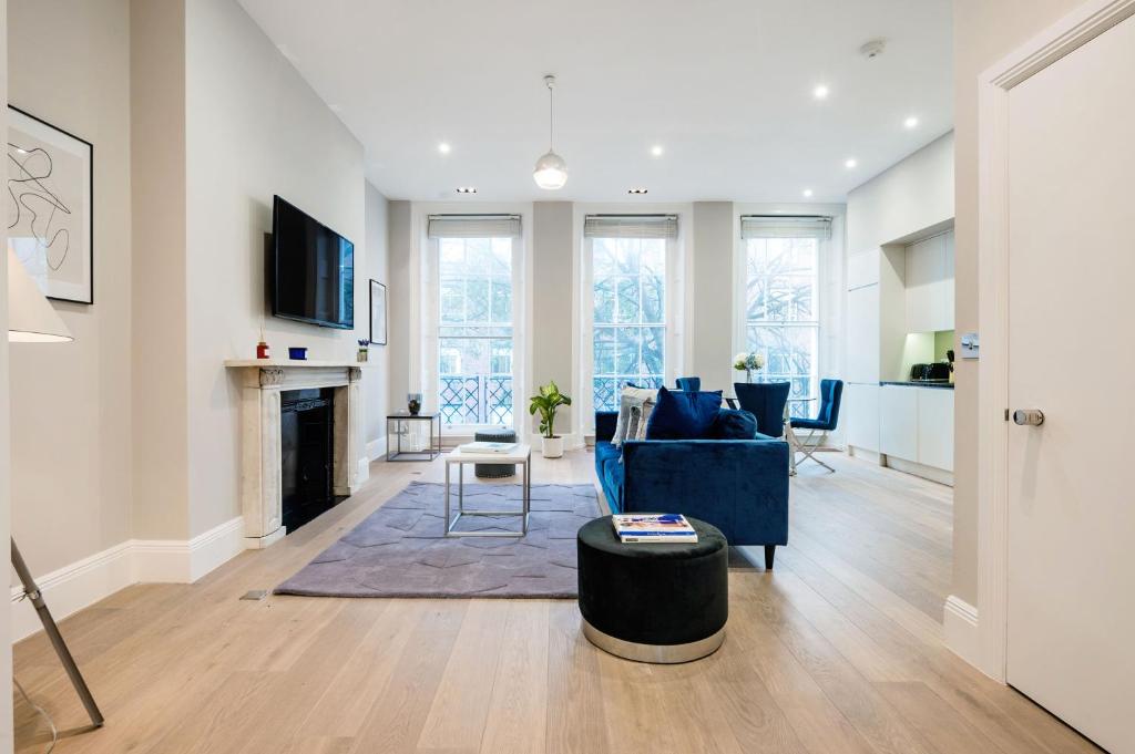 a living room with a blue couch and a fireplace at ARCORE Premium Apartments Bloomsbury in London