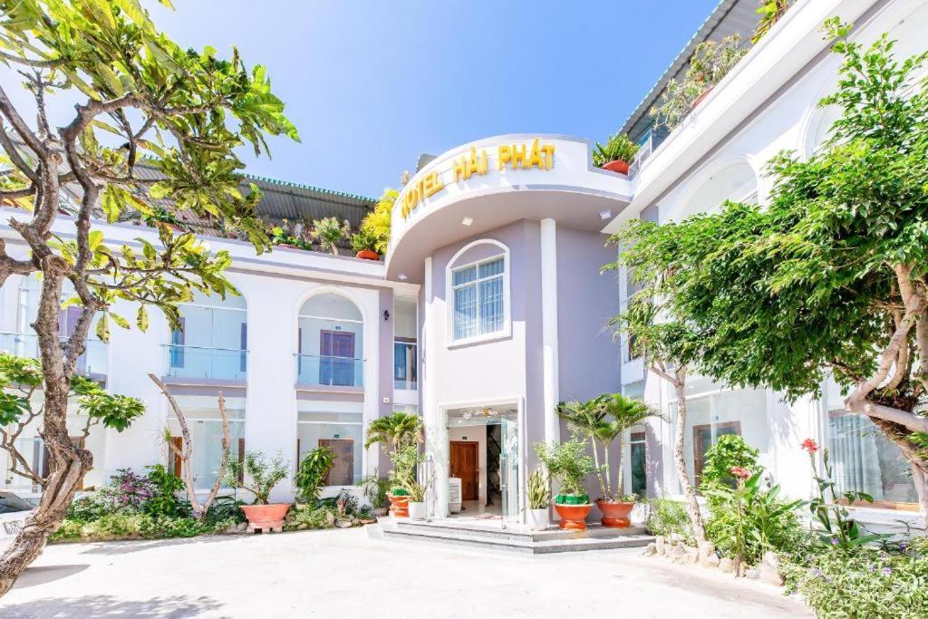 uma vista exterior de uma casa branca com árvores em Hải Phát Hotel em Thôn Trà Long