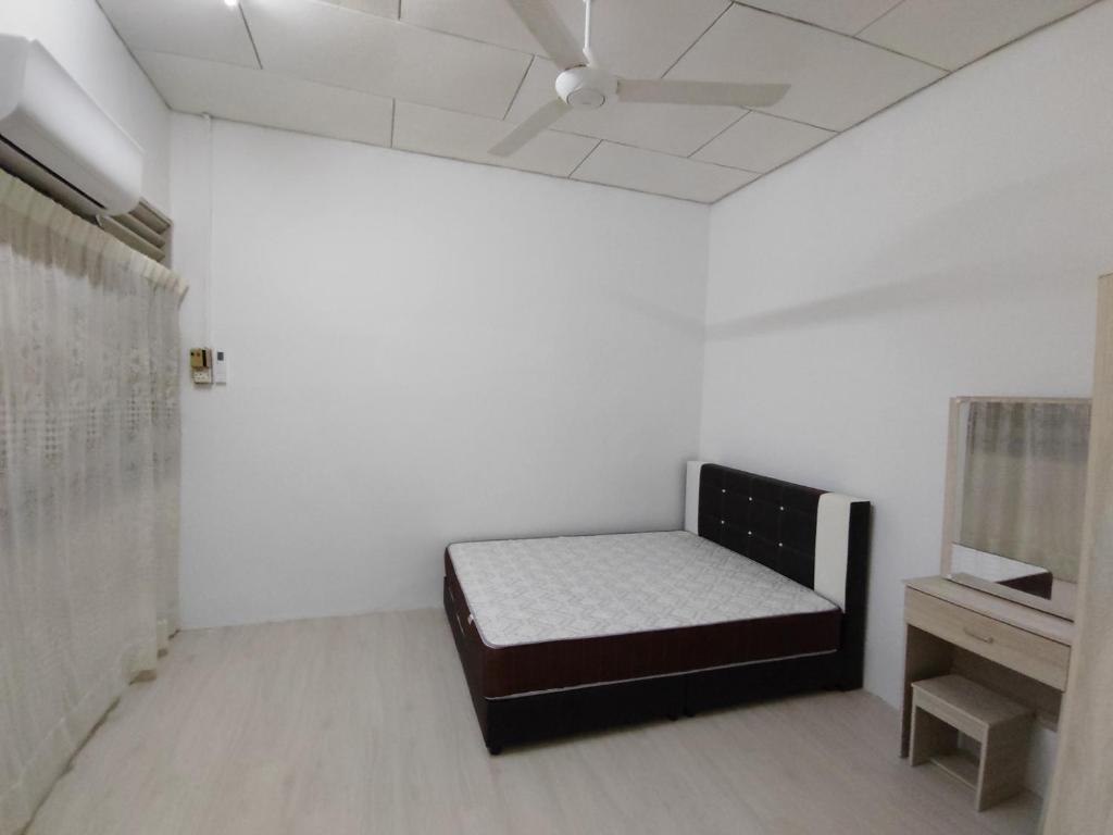 ein weißes Zimmer mit einem Bett und einem Tisch in der Unterkunft GP Hostel Penang in George Town