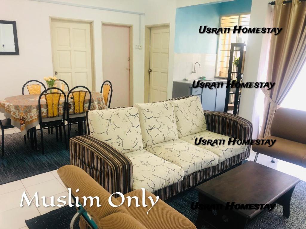 uma sala de estar com um sofá e uma mesa em Usrati Homestay by Amirul em Porto Dickson