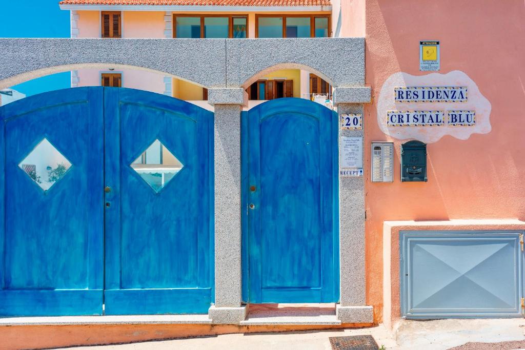 a pair of blue doors on a building at Apartments with swimming pool in Santa Teresa di Gallura in Santa Teresa Gallura