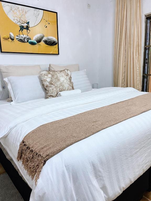 a bedroom with a large bed with white sheets at Ranzi Court in Palatswe