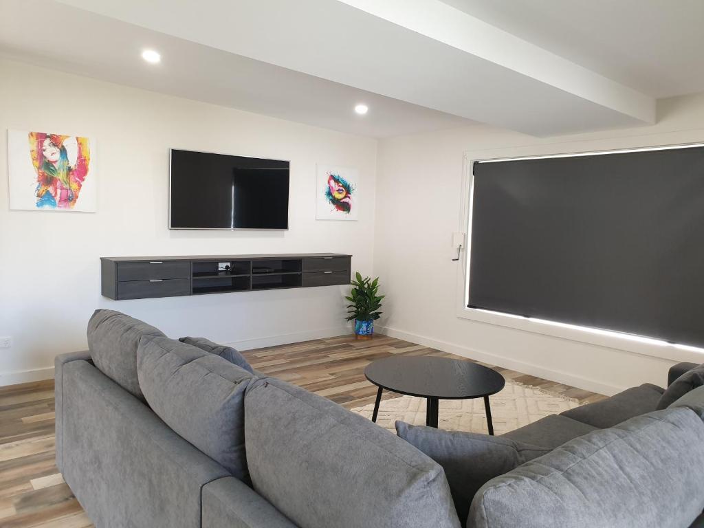 a living room with a couch and a flat screen tv at Heinlen on Bridges Street in Mount Gambier