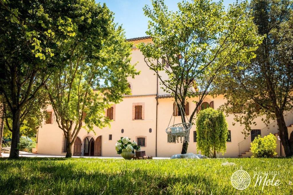 duży budynek z drzewami przed nim w obiekcie Borgo delle Mole w mieście Spoleto