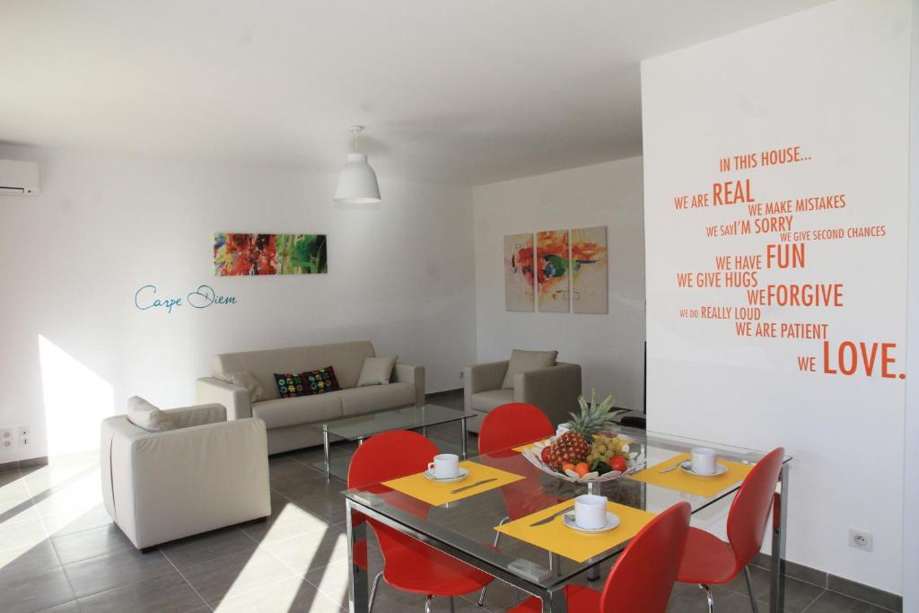 a living room with a table and red chairs at Résidence Isola Hotel in Borgo