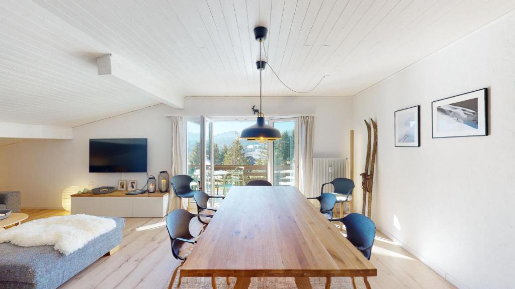 a dining room with a large wooden table and chairs at Ski in-Ski out Apartment Luscheina-Lenzerheide in Valbella