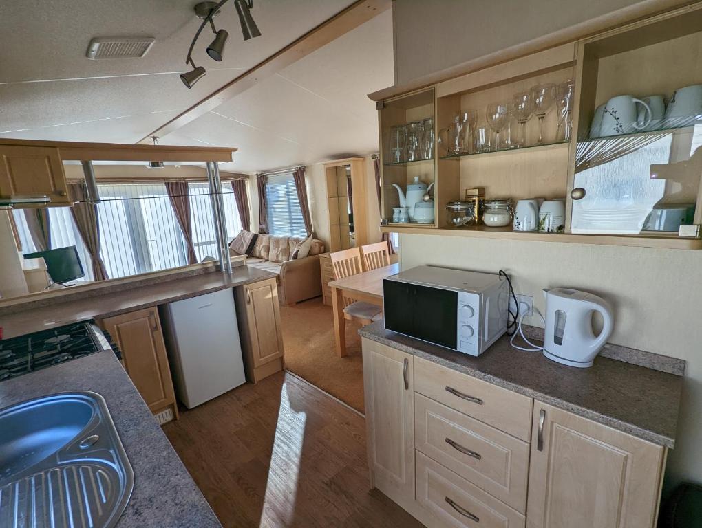 a kitchen and living room of an rv at Park Home at Lyons Winkups Holiday Park N.Wales in Kinmel Bay
