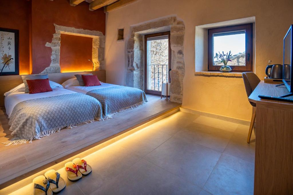 um quarto com duas camas e alguns sapatos em Hotel japonès Puigpinós em Lladurs