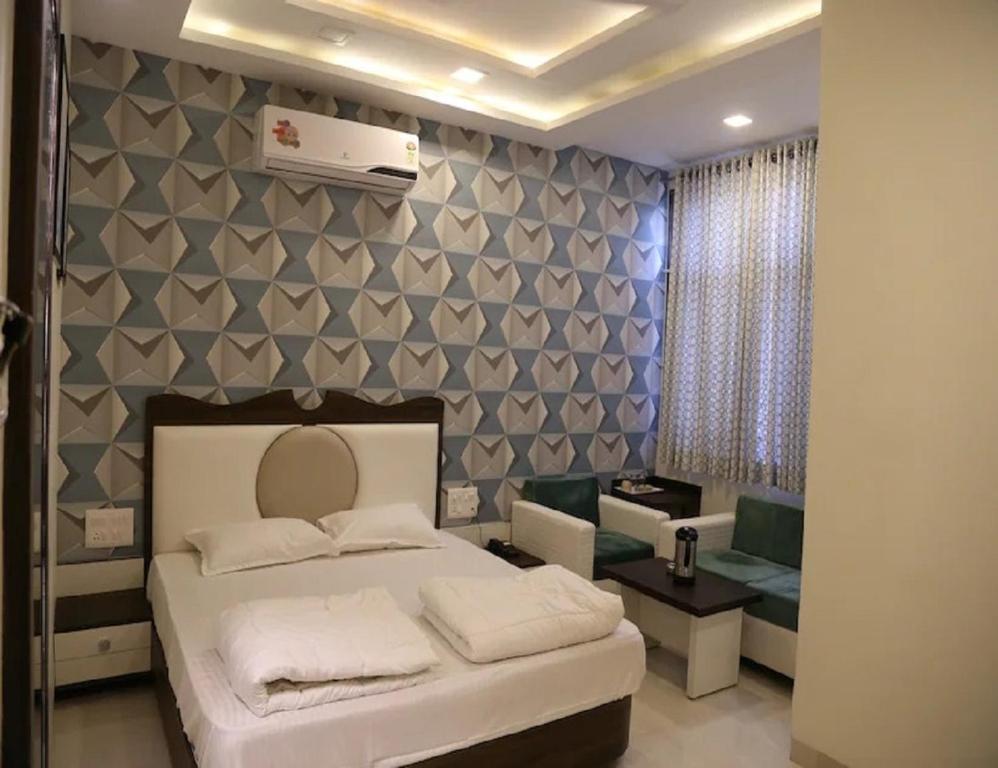 a bedroom with a bed and a room with a couch at Hotel Gopal, Khargone in Khargon