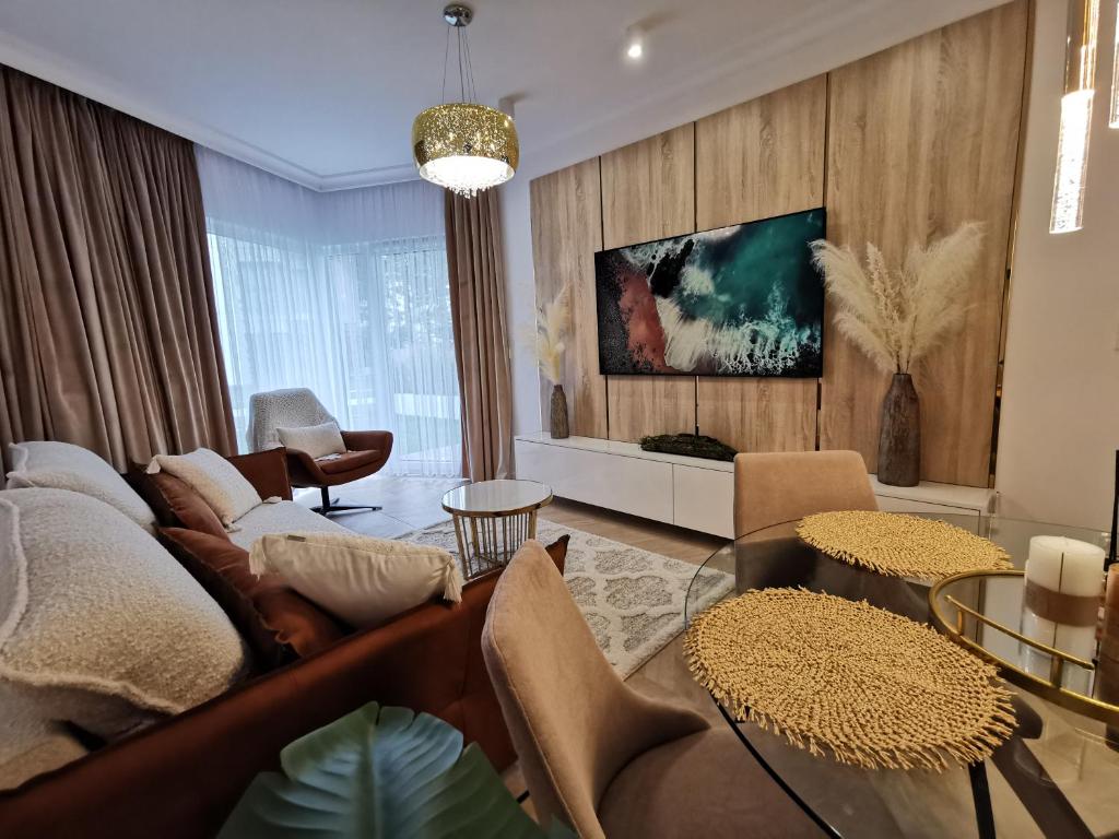 a living room with a couch and a table at Gold Apartment B28 Let's Sea Baltic Park Gąski in Gąski
