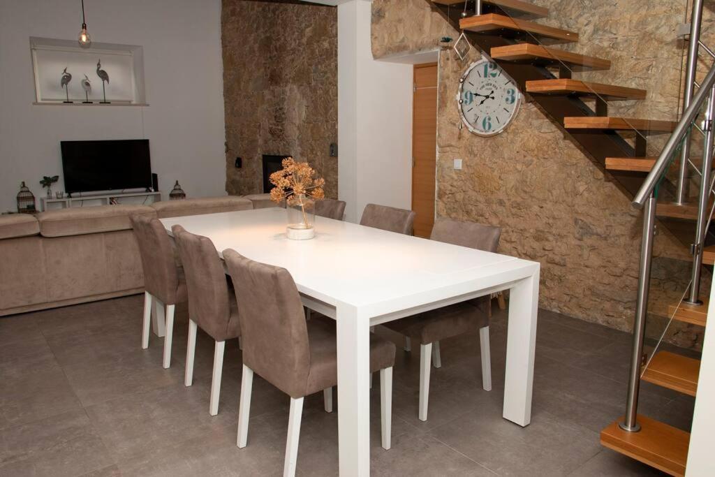 una sala da pranzo con tavolo e sedie bianchi di Beautiful cozy cottage near Nazaré, Leiria&Batalha a Juncal
