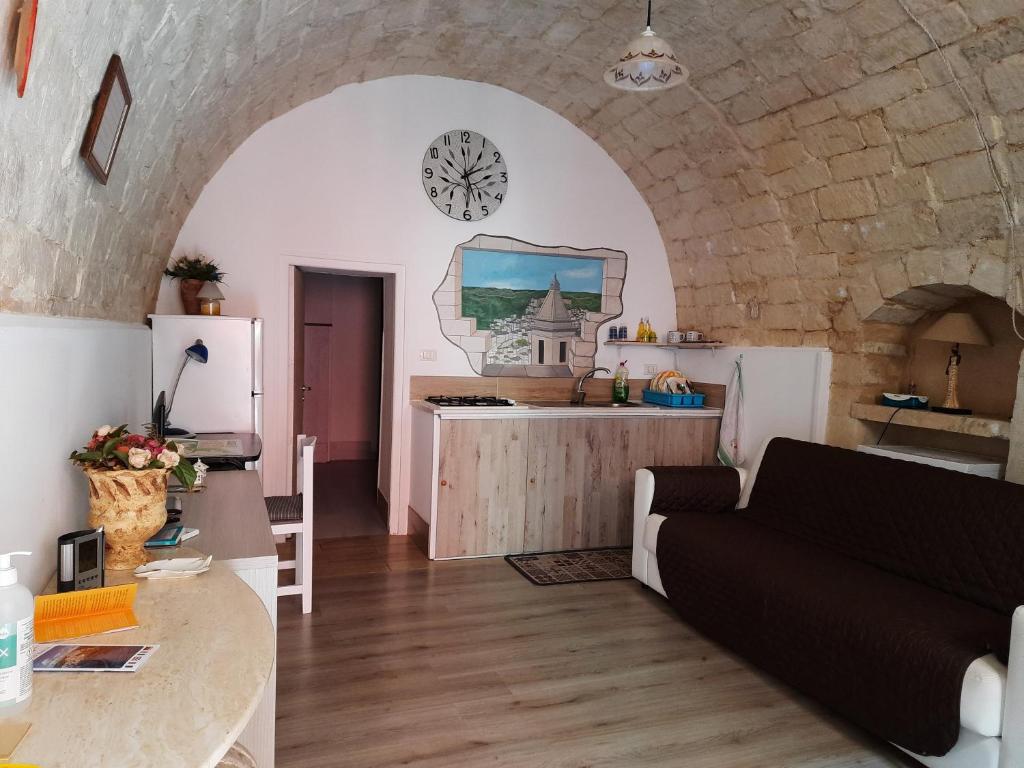 a kitchen and a living room with a clock on the wall at La Nicchia in Ragusa