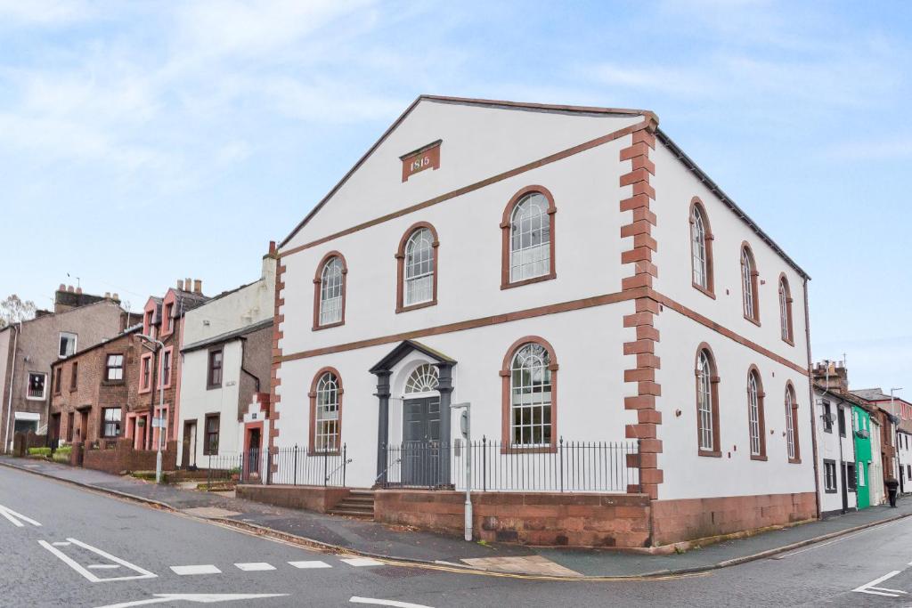 un edificio blanco al lado de una calle en Sandgate Chapel - Self Check In Apartments, en Penrith