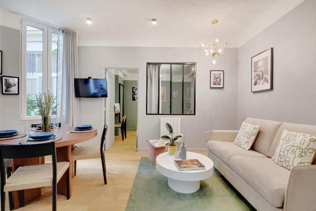 - un salon avec un canapé et une table dans l'établissement Bastille - Cosy design 1BR / 4P apartment, à Paris