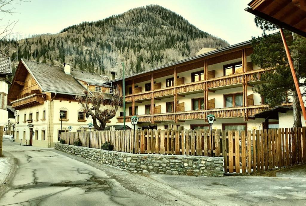 una recinzione di legno davanti a un edificio di das MARX - Gasthof Marx - Apartments a Grosskirchheim