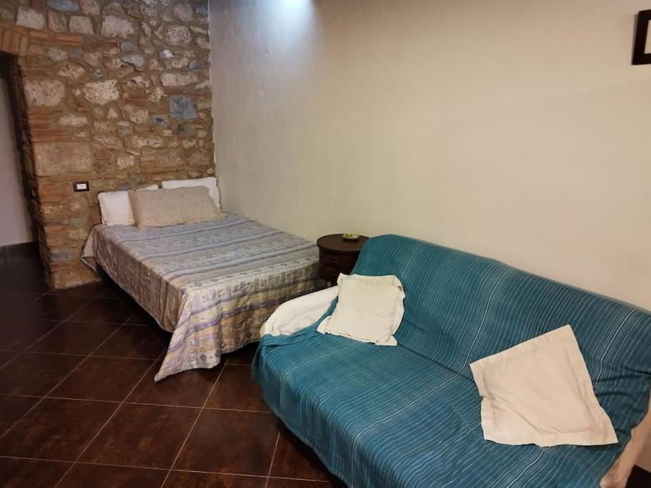 ein Wohnzimmer mit einem Sofa und einem Bett in der Unterkunft La taverna sotto la torre in Massa Marittima