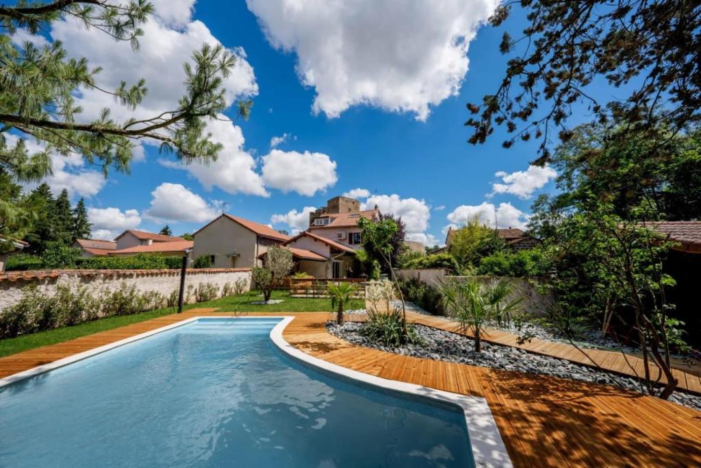 - une piscine dans une cour avec une maison en arrière-plan dans l'établissement Gite du chateau, à Montrond-les-Bains