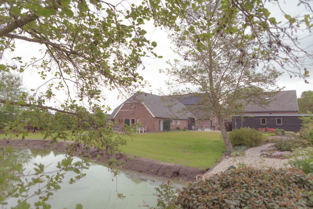 a house with a pond in front of it at Hessener Esch in Dalfsen