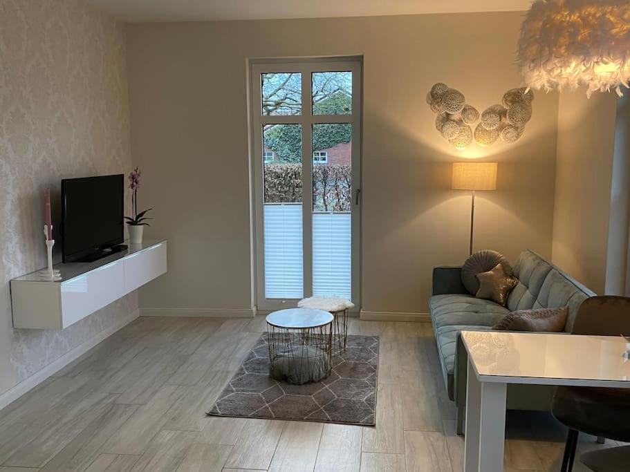 a living room with a couch and a tv at Schöne Ferienwohnung im Ergeschoss mit Terrasse in Ahaus