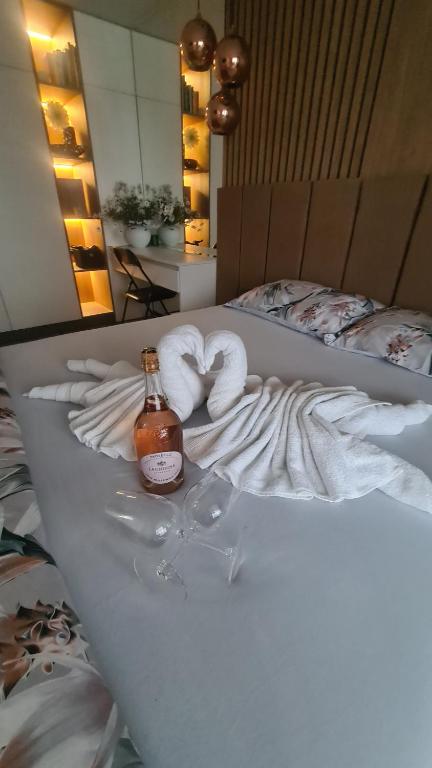 1 cama con 2 toallas y 1 botella de alcohol en Апартамент Мегилукс 2 en Blagoevgrad